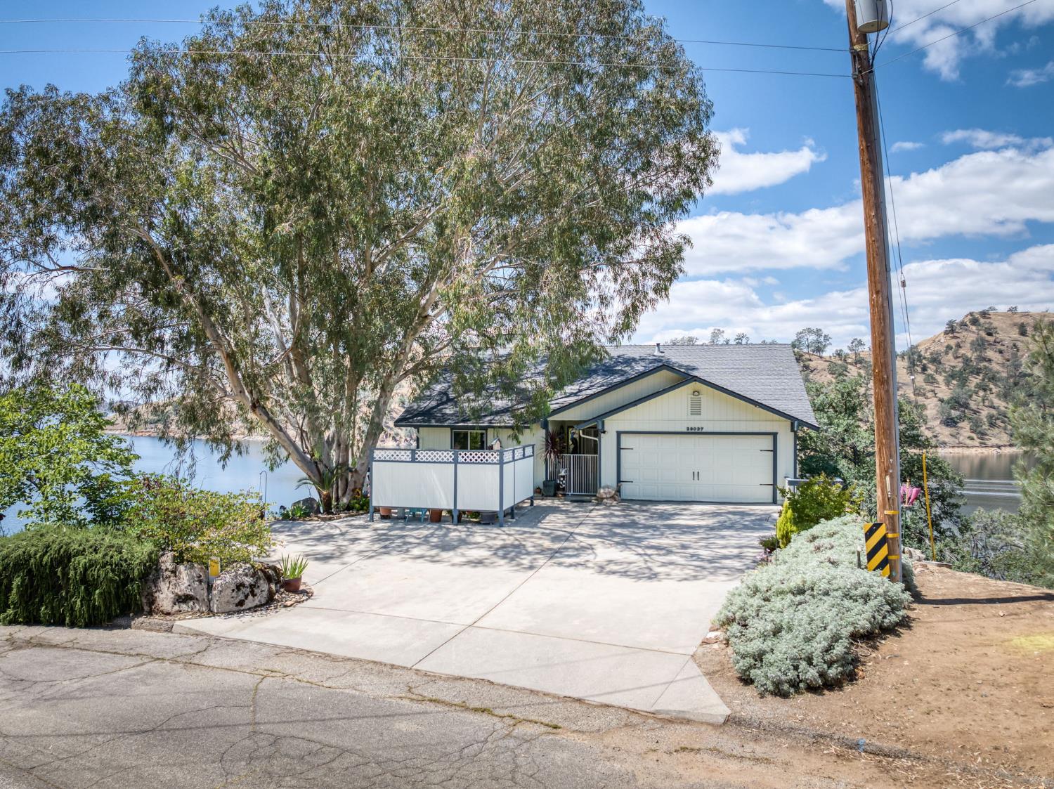 28037 Sky Harbour Road Friant, CA 93626 - Photo 33 of 40 a view of a white house next to a yard with large trees