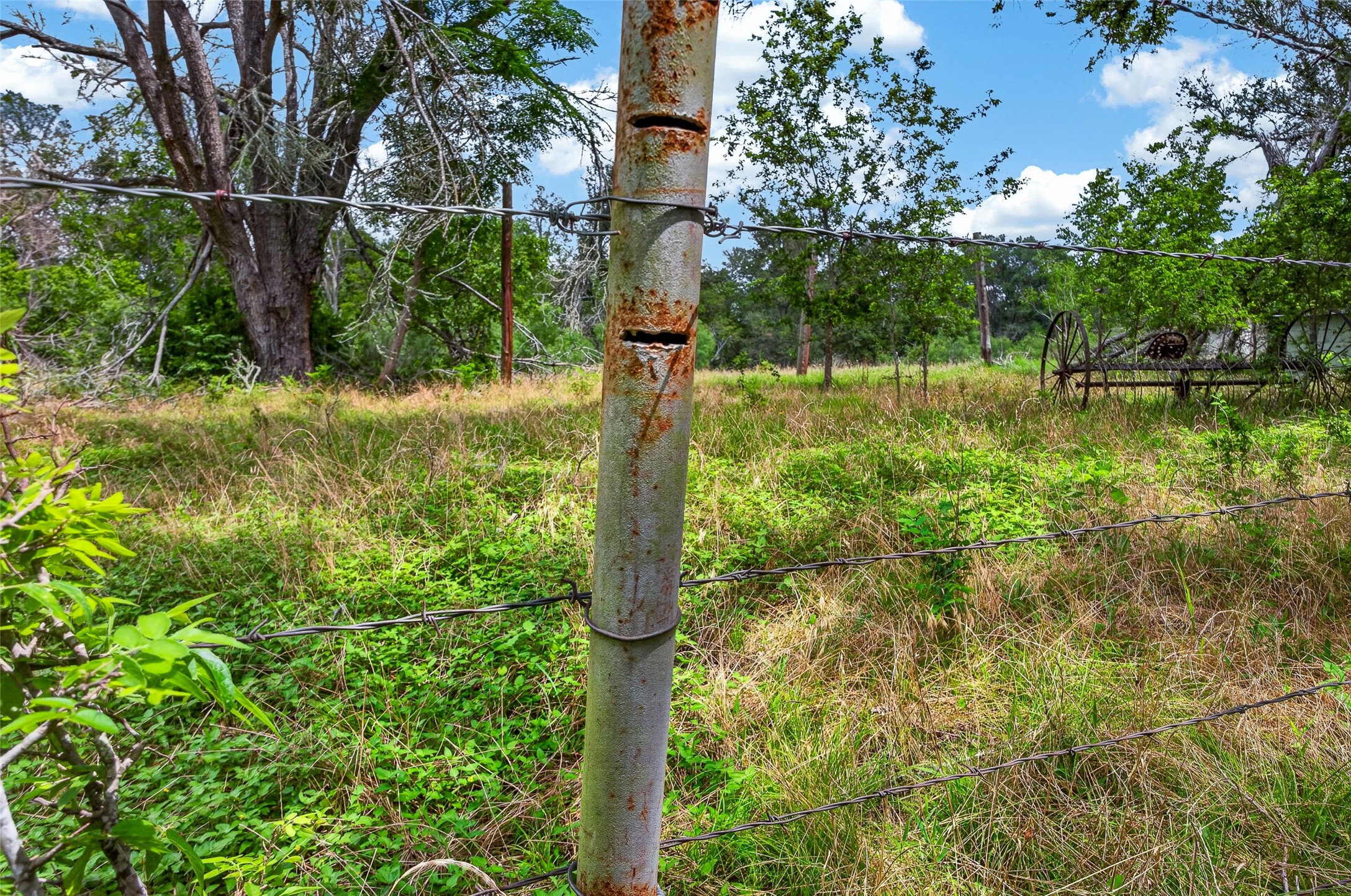 266 Beaver Road Elgin, TX 78621 - Photo 30 of 40 A rustic barbed wire fence defines the boundary of this verdant land, ideal for future plans.