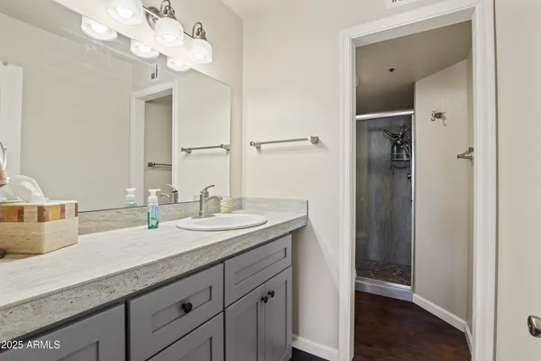 a spacious bathroom with a granite countertop sink and a mirror