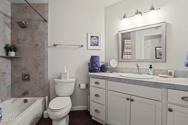 a bathroom with a granite countertop toilet a sink and a bathtub