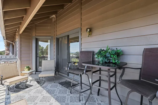 a patio with table and chairs and potted plants