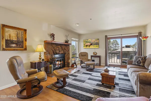 a living room with furniture fireplace and a large window