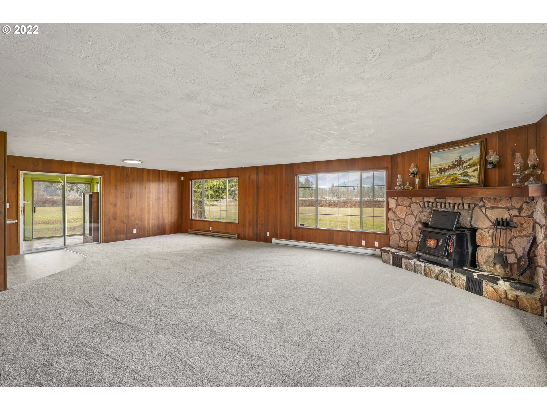 84926 Cloverdale Road Creswell, OR 97426 - Photo 5 of 31 a view of an empty room with a fireplace and windows