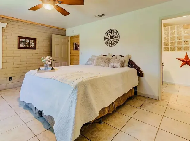 a bed sitting in a spacious bedroom next to a window