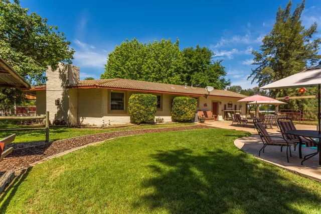 a view of a house with a yard and a tree