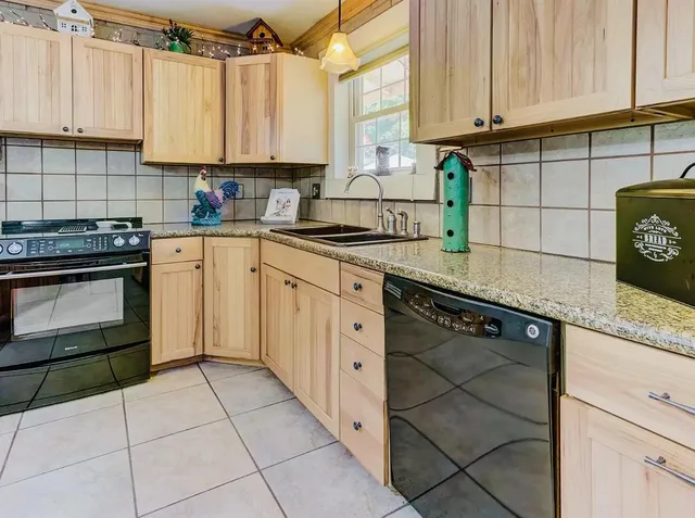 a kitchen with granite countertop a stove sink and cabinets