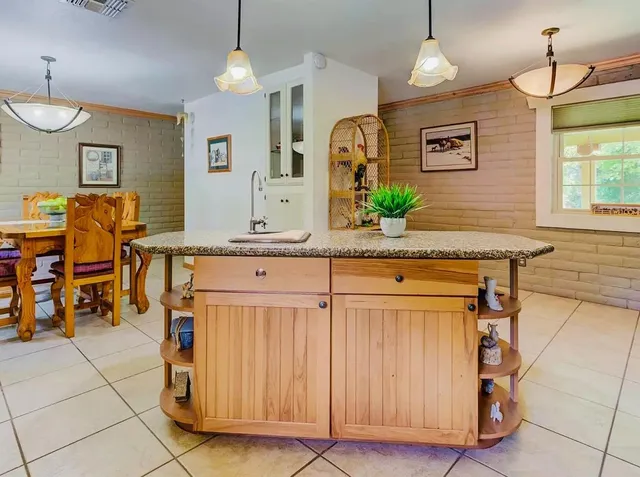 a spacious kitchen with stainless steel appliances granite countertop a stove a sink and a refrigerator