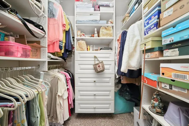 a view of walk in closet with clothes and shoes