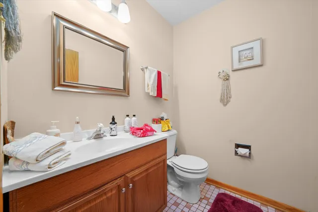a bathroom with a toilet sink vanity and mirror
