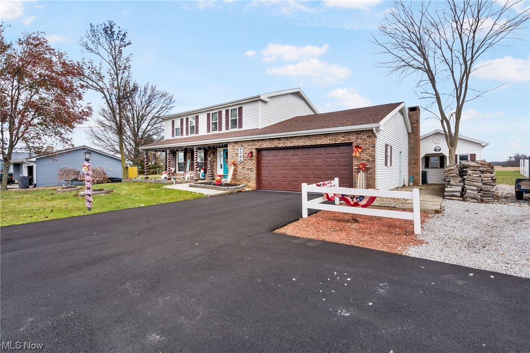 View of front of property featuring a front lawn and a garage