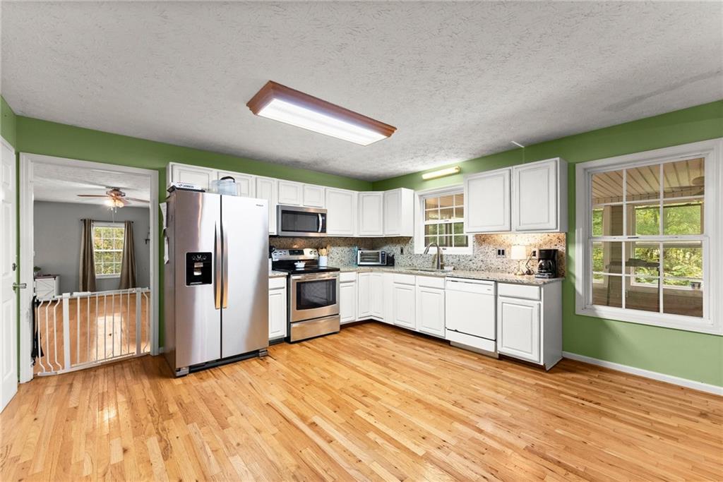 7540 County Line Road Lula, GA 30554 - Photo 15 of 64 a kitchen with granite countertop a refrigerator and white cabinets