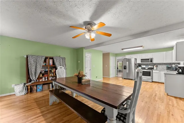 a view of a livingroom with furniture hardwood floor and a ceiling fan