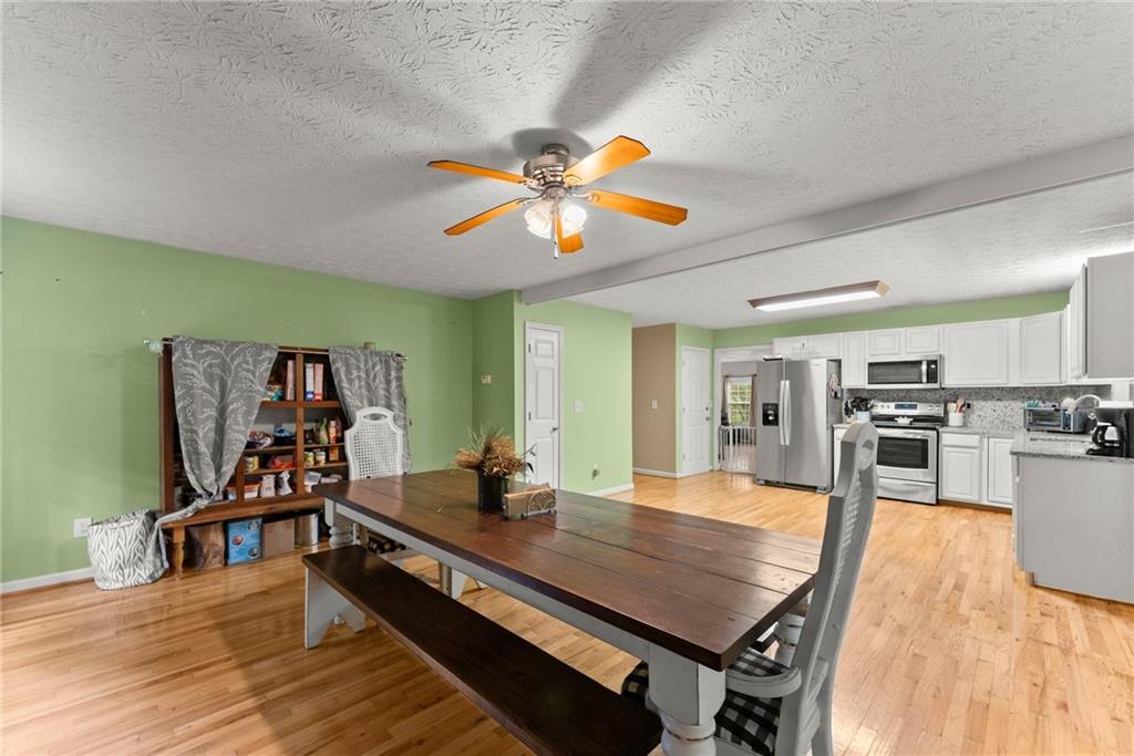 7540 County Line Road Lula, GA 30554 - Photo 18 of 64 a room with stainless steel appliances lots of wooden furniture dining table and chairs