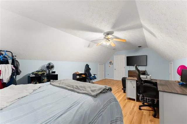 a bedroom with a bed and a flat tv screen on the dresser