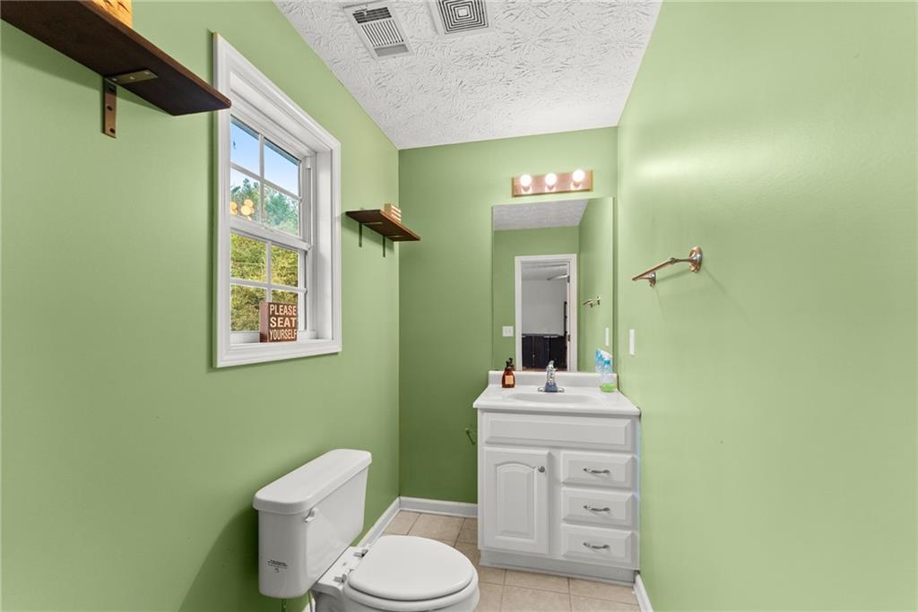 7540 County Line Road Lula, GA 30554 - Photo 28 of 64 a bathroom with a toilet a sink and a mirror