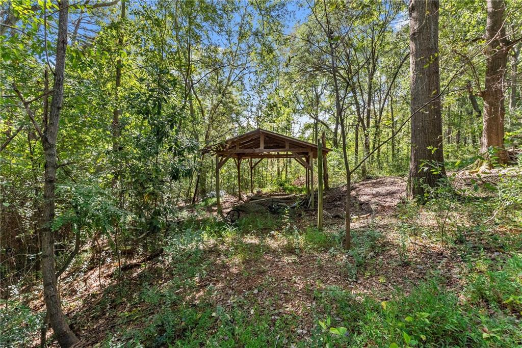 7540 County Line Road Lula, GA 30554 - Photo 43 of 64 a view of a garden with a bench and trees