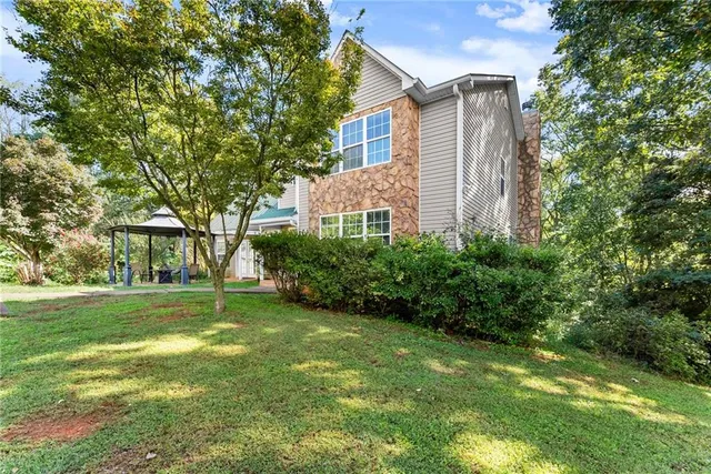 a view of a backyard with plants and large trees