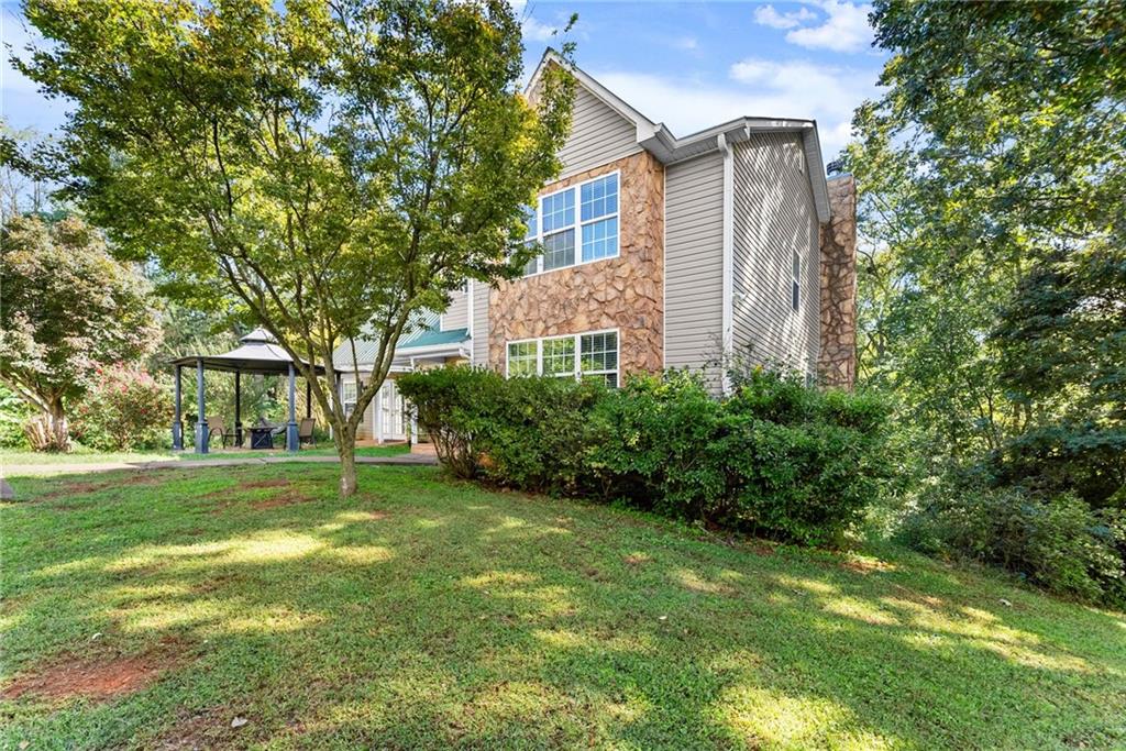7540 County Line Road Lula, GA 30554 - Photo 5 of 64 a view of a backyard with plants and large trees
