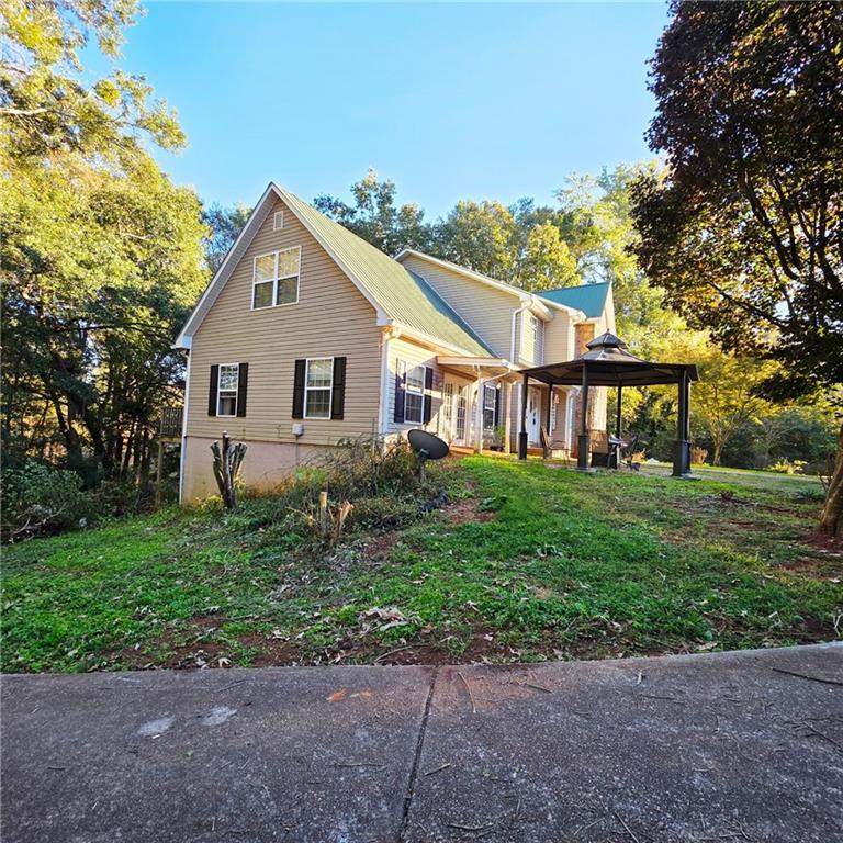 7540 County Line Road Lula, GA 30554 - Photo 6 of 64 a view of a yard in front of a house with large windows