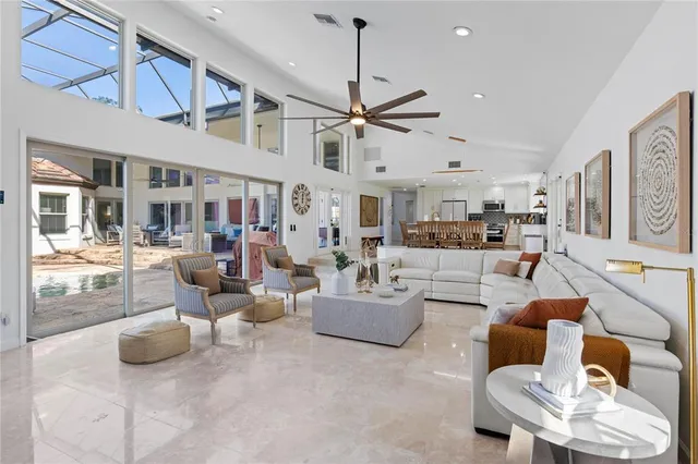 a living room with furniture a fireplace and a floor to ceiling window
