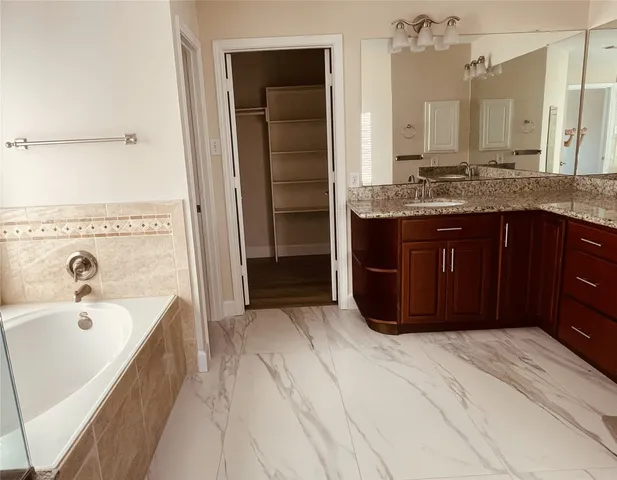 a bathroom with a tub sink and mirror
