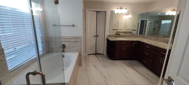 a bathroom with a granite countertop sink a toilet a mirror and shower