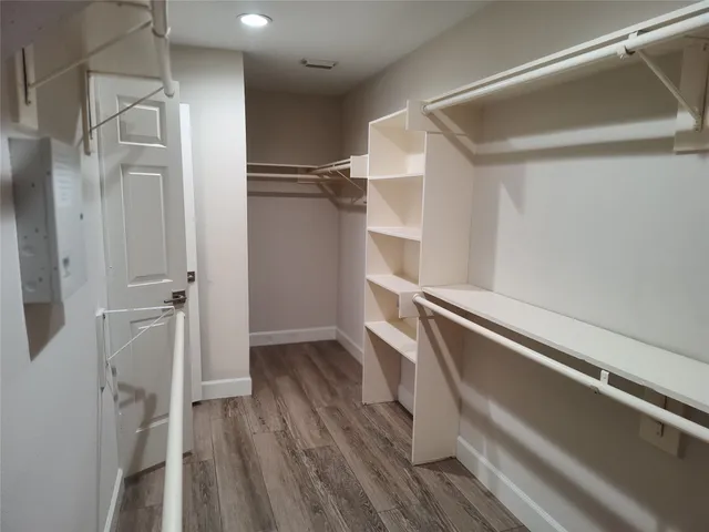 a view of walk in closet with wooden floor