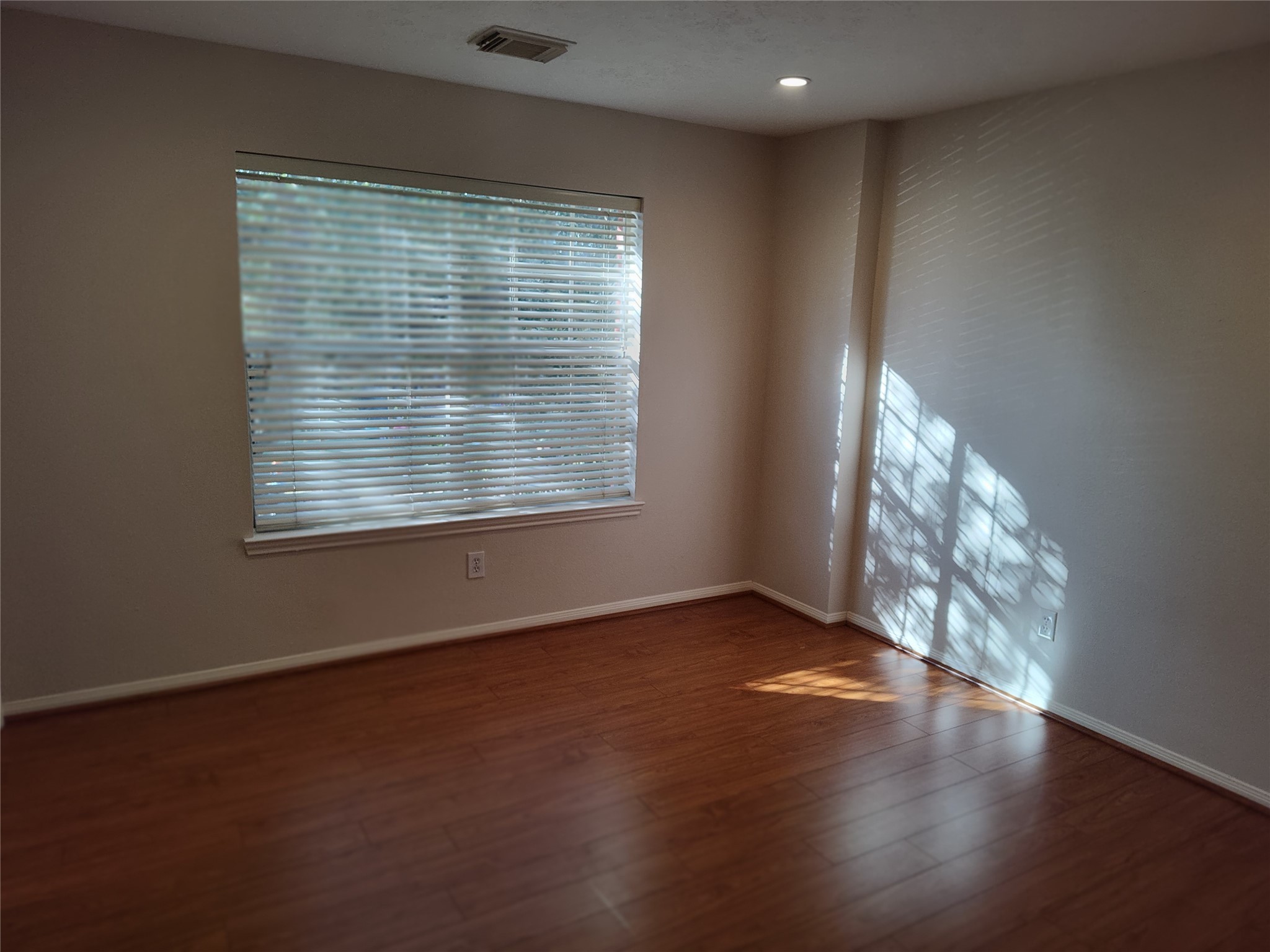 4127 North Nolan Place Pearland, TX 77584 - Photo 19 of 25 an empty room with wooden floor and windows