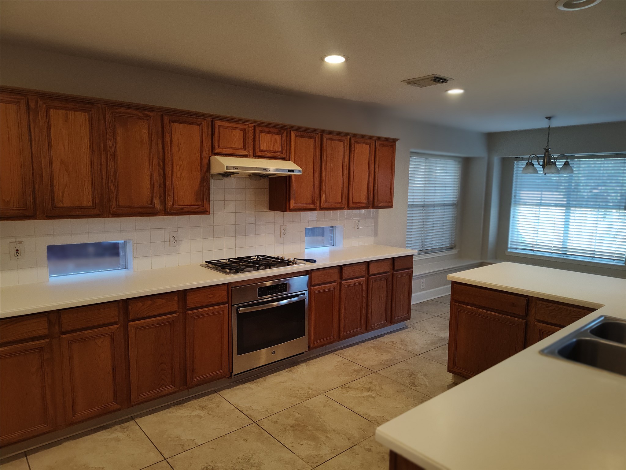 4127 North Nolan Place Pearland, TX 77584 - Photo 5 of 25 a kitchen with stainless steel appliances granite countertop wooden cabinets a stove top oven a sink and dishwasher