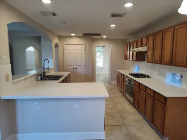 a large kitchen with kitchen island a sink a stove and a refrigerator