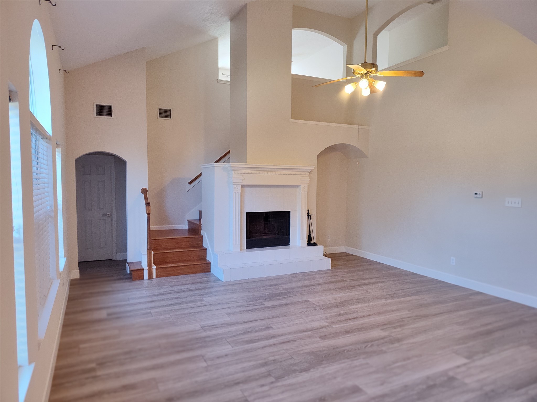 4127 North Nolan Place Pearland, TX 77584 - Photo 9 of 25 an empty room with wooden floor fireplace and staircase