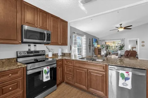 a kitchen with stainless steel appliances granite countertop a stove microwave and sink