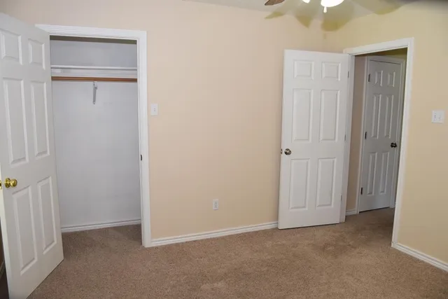 an empty room with windows and closet