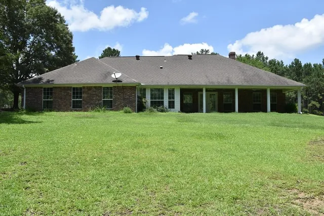 a view of a house with yard and sitting area