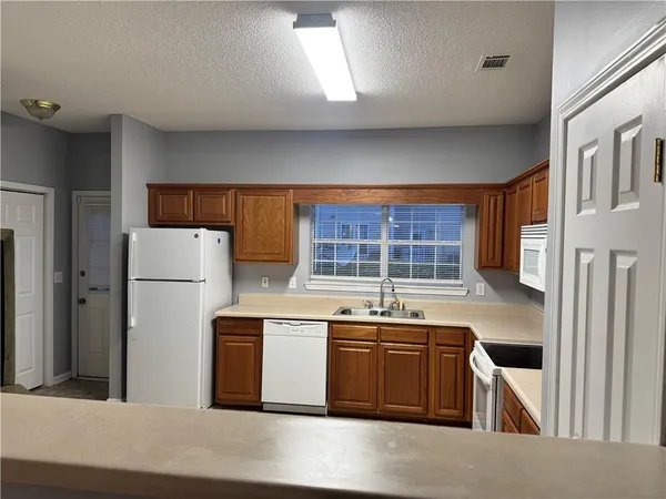 a kitchen with a stove a refrigerator and a sink