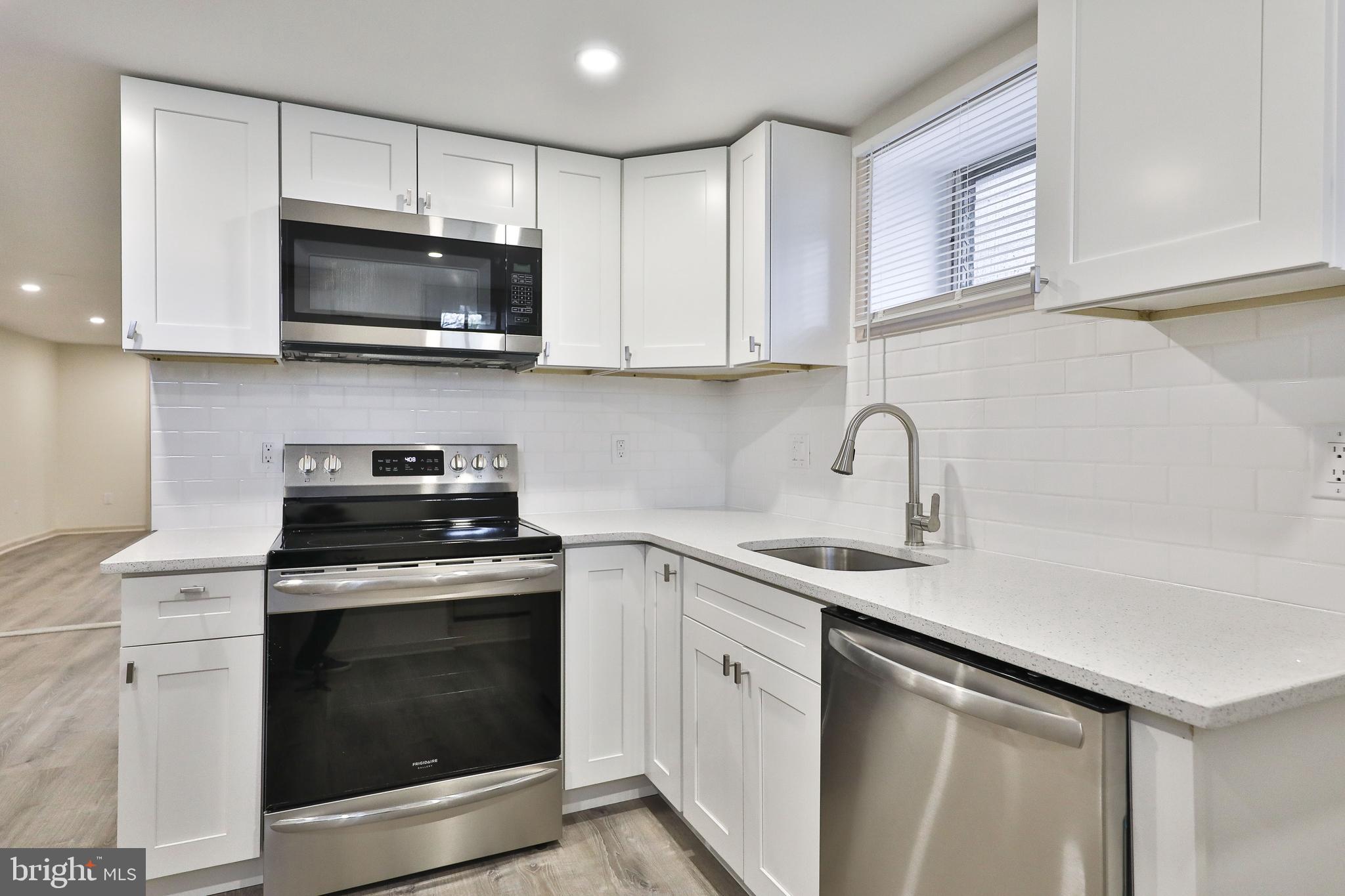 314 Huntingdon Pike, Unit 314A Jenkintown, PA 19046 - Photo 4 of 14 a kitchen with white cabinets stainless steel appliances and sink