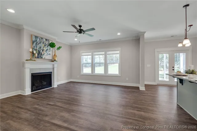 a view of an empty room with window and wooden floor
