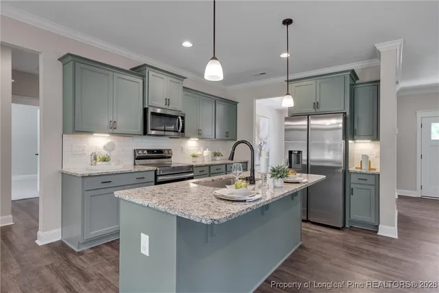 a kitchen with stainless steel appliances granite countertop a refrigerator a sink a stove a microwave and wooden floor