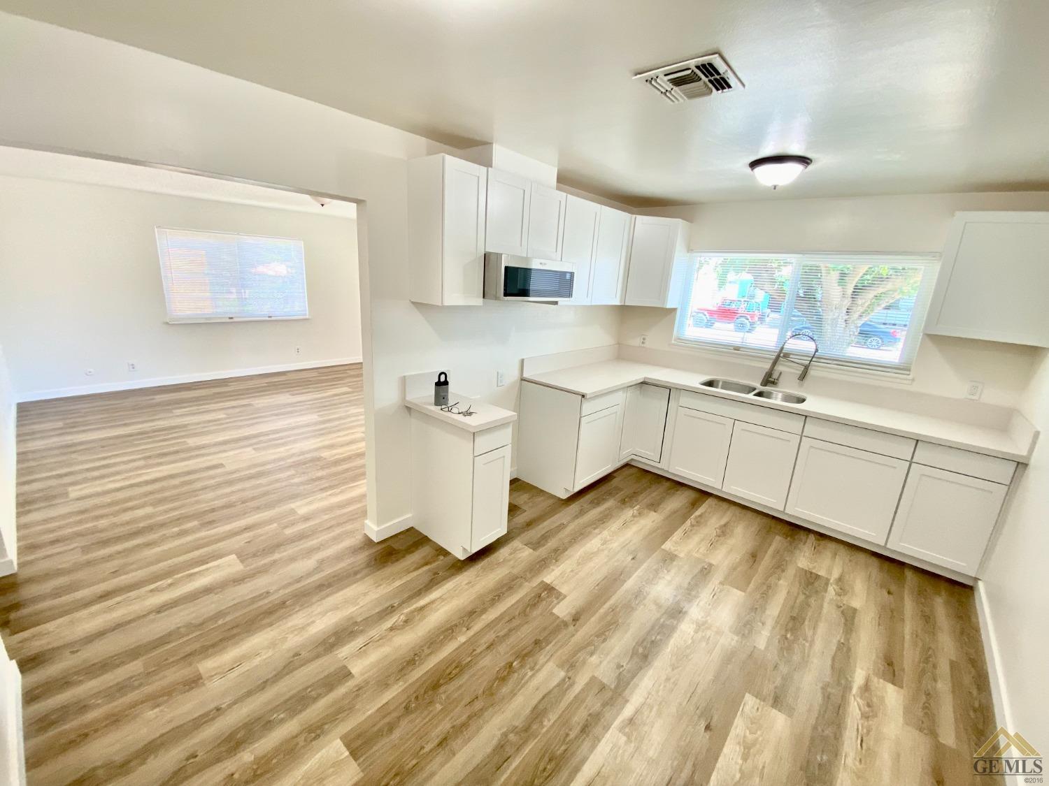 Undisclosed Address Wasco, CA 93280 - Photo 3 of 10 a room with white cabinets and sink