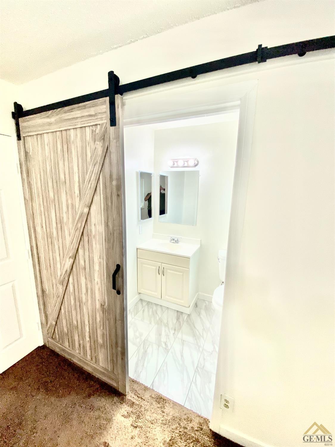 Undisclosed Address Wasco, CA 93280 - Photo 5 of 10 a view of a bathroom with a sink and a mirror