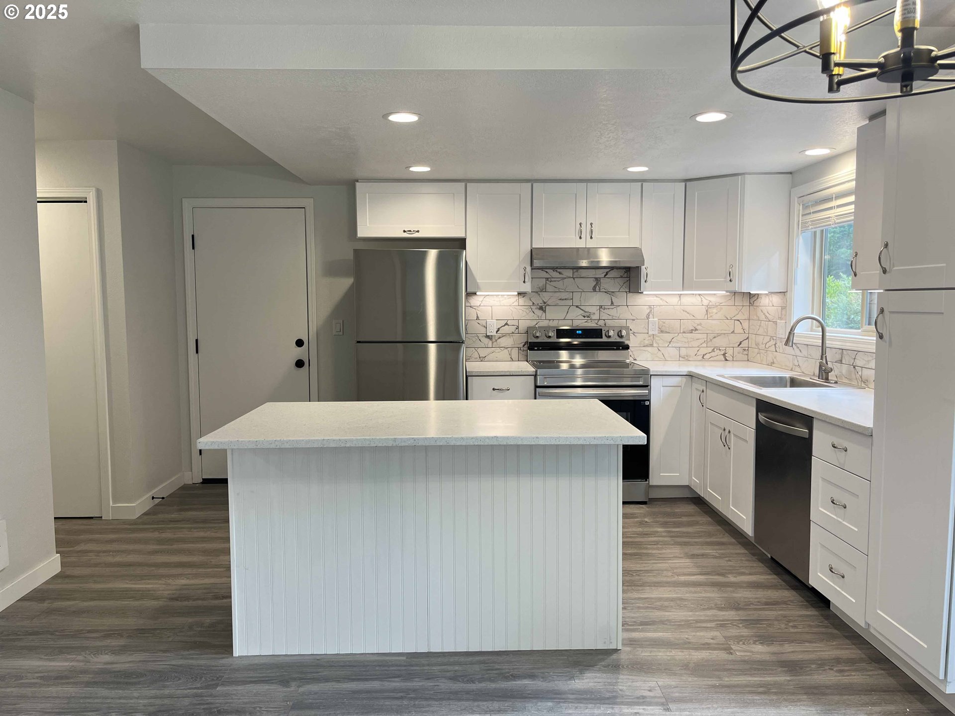 2040 11th Street Florence, OR 97439 - Photo 12 of 43 a kitchen with kitchen island a sink stainless steel appliances and cabinets