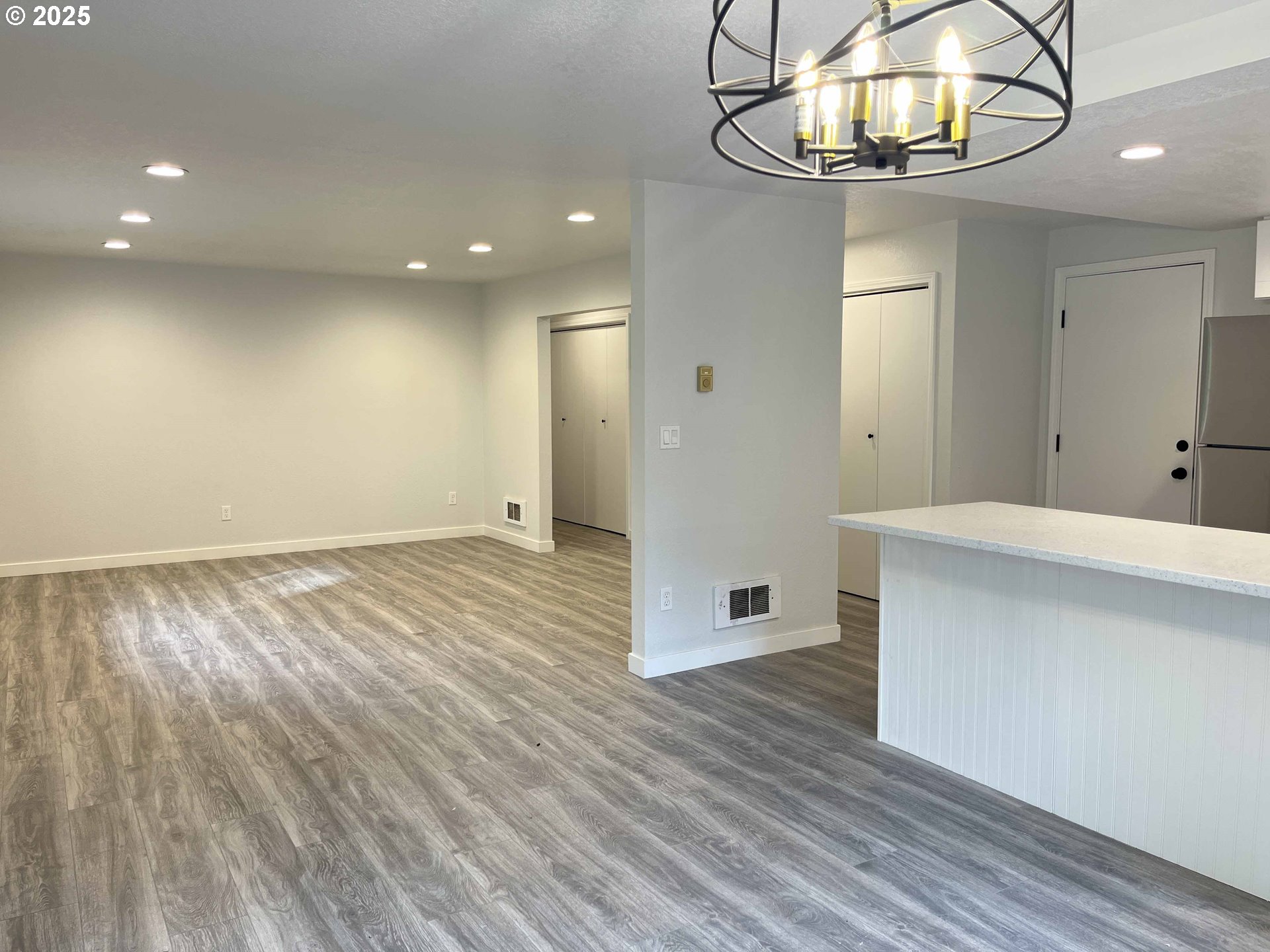 2040 11th Street Florence, OR 97439 - Photo 13 of 43 wooden floor in an empty room with a chandelier