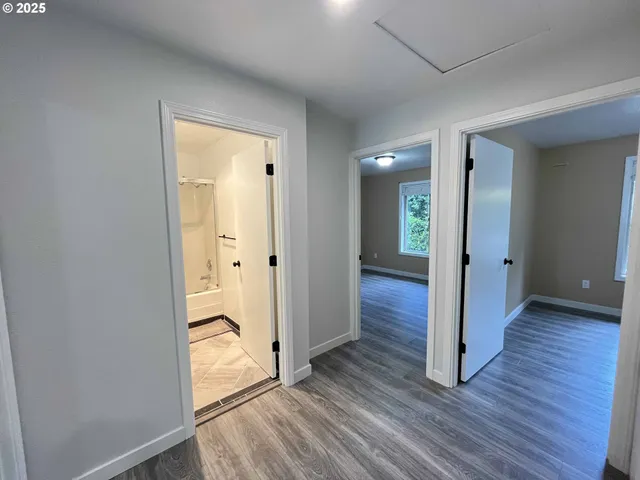 an empty room with wooden floor and entrance