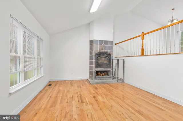 a view of an empty room with a fireplace and a window