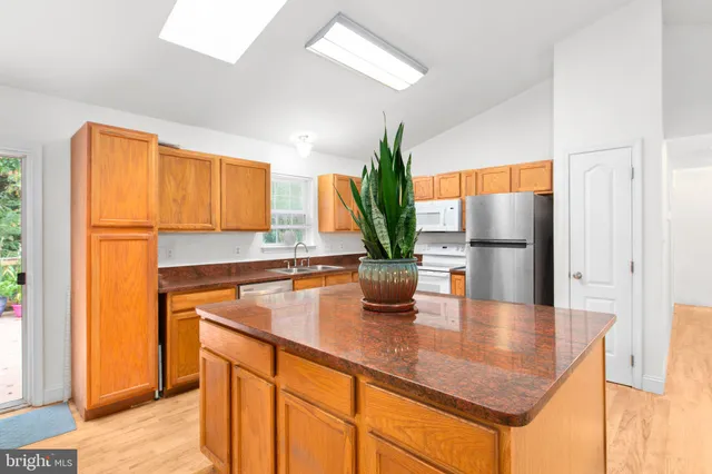 a kitchen with stainless steel appliances granite countertop sink stove and refrigerator