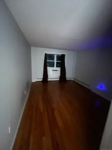a view of a livingroom with wooden floor and a window