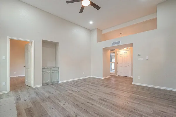 an empty room with wooden floor and windows