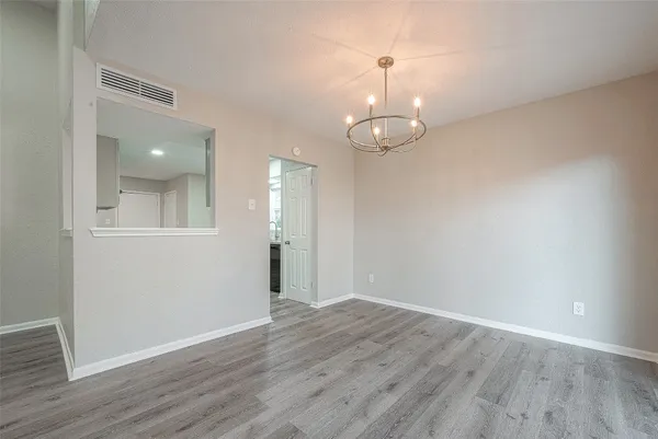 a kitchen with stainless steel appliances granite countertop a stove top oven a sink dishwasher and a refrigerator with wooden floor