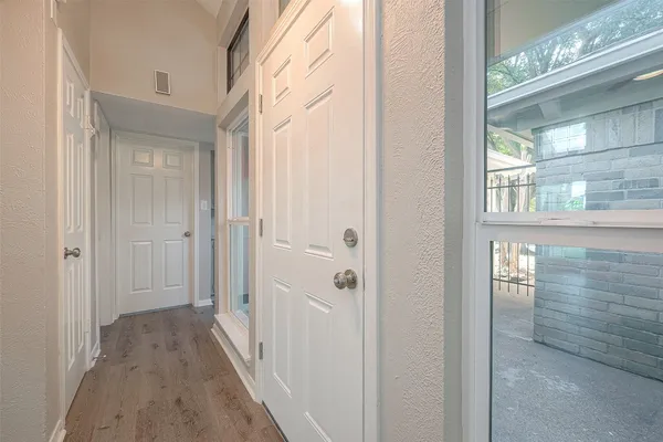 an empty room with wooden floor fireplace and windows
