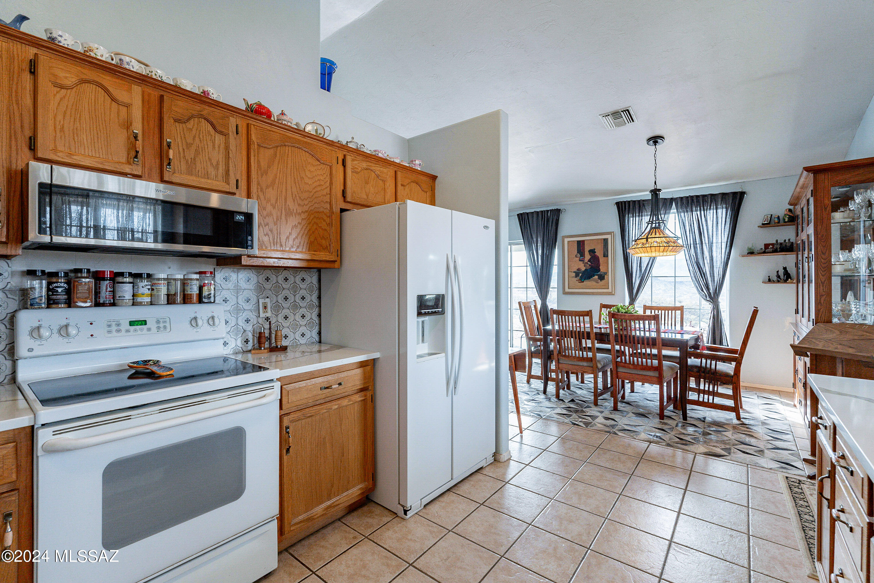 456 Camino Providencia Rio Rico, AZ 85648 - Photo 17 of 45 a kitchen with stainless steel appliances a stove a sink cabinets and a dining table